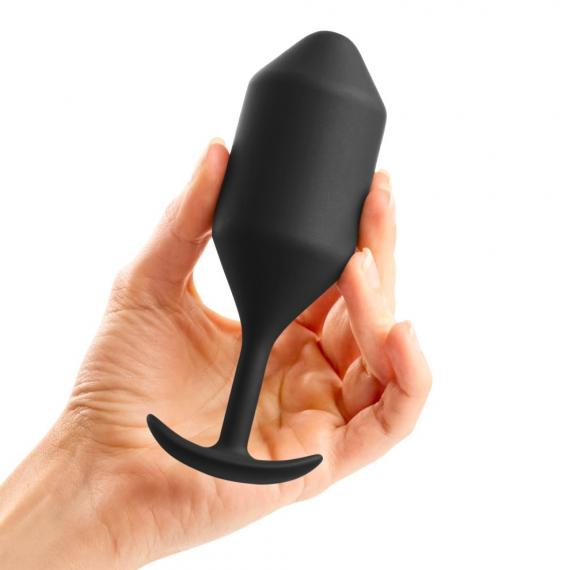 Hand holding B-vibe Snug Plug 4 Weighted Silicone Butt Plug - 257 grams