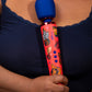 Le Wand Feel My Power 2022 Special Edition Rechargeable Wand Vibrator held in a woman's hand against her chest