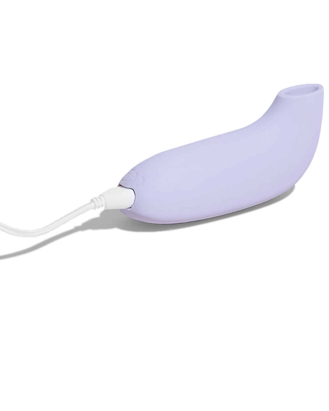 Aer Clitoral Suction Toy Vibrator by Dame Products  on bed with charger cord 
